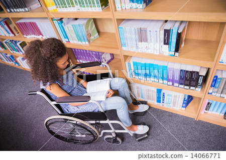 Smiling disabled student in library reading book 14066771