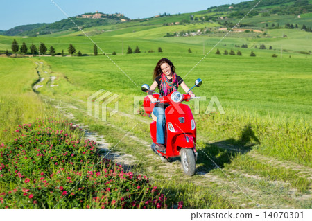 Young woman traveling by a scooter Young woman traveling by a scooter 14070301