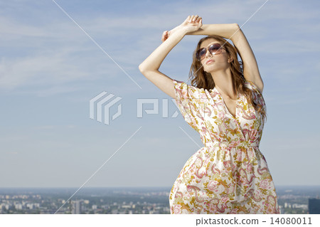 beautiful girl in sunglasses on background blue sky 14080011