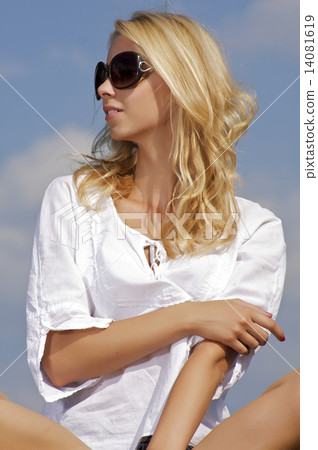 beautiful girl in sunglasses on background blue sky 14081619