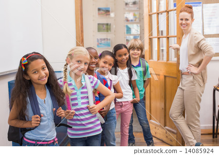 Cute pupils smiling at camera in classroom 14085924
