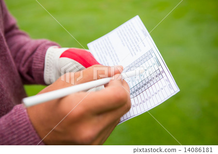 Golfer writing his points in paper 14086181