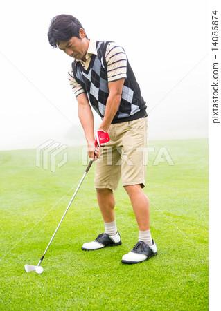 Concentrating golfer lining up his shot Concentrating golfer lining up his shot 14086874