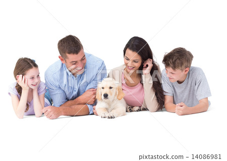Family looking at puppy while lying 14086981