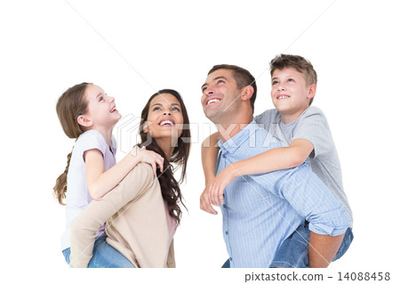 Parents giving piggyback ride to children while looking up 14088458