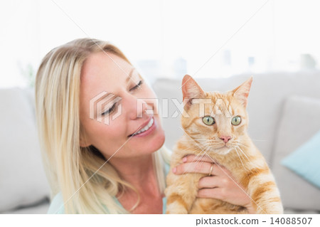 Young woman holding cat at home Young woman holding cat at home 14088507