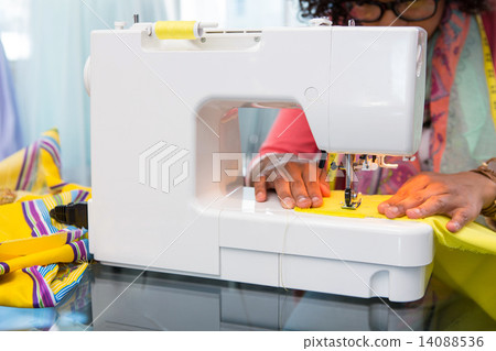 Fashion designer using sewing machine Fashion designer using sewing machine 14088536