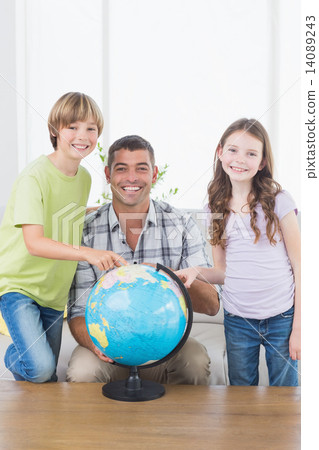 Father with son and daughter exploring map on globe 14089243