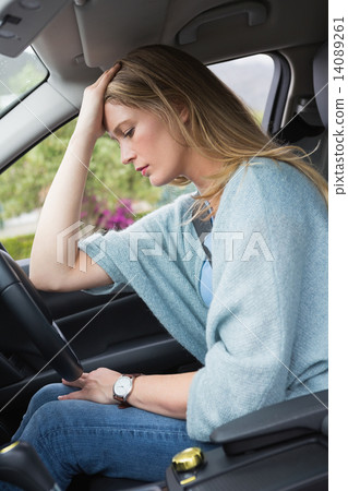 Worried woman sitting in drivers seat 14089261