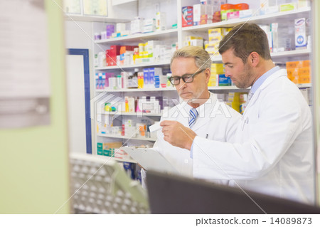 Senior pharmacist reading a prescription on clipboard Senior pharmacist reading a prescription on clipboard 14089873