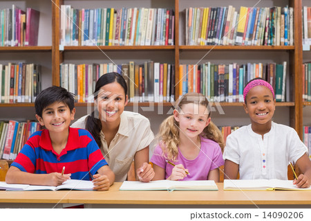 Pretty teacher helping pupils in library Pretty teacher helping pupils in library 14090206