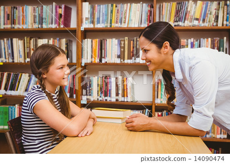 Female teacher and little girl in library 14090474