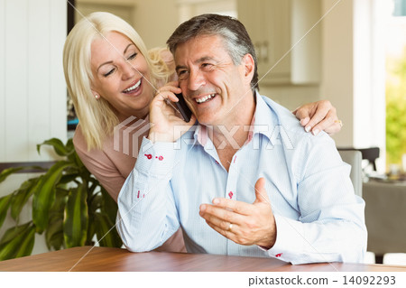Happy mature couple using smartphone together Happy mature couple using smartphone together 14092293
