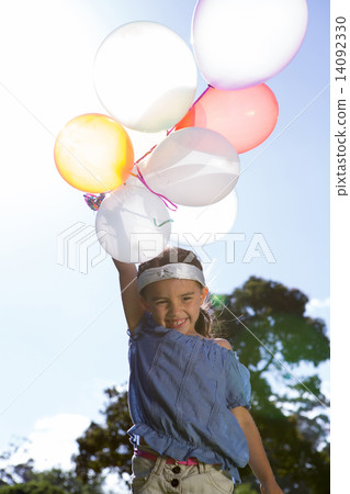 Happy little girl holding balloons 14092330