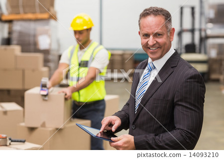 Boss using digital tablet in warehouse Boss using digital tablet in warehouse 14093210