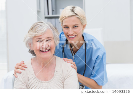 Nurse with hands on senior patients shoulders in clinic 14093336