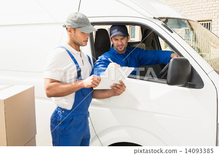Delivery driver showing customer where to sign Delivery driver showing customer where to sign 14093385