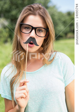 Pretty blonde smiling at camera with fake mustache 14093744