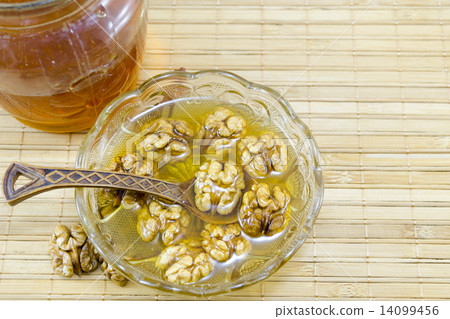 Walnuts and honey in a glass dish 14099456