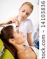 young woman getting beauty skin mask treatment on her face with 14103836