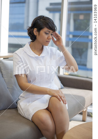 An Asian stressed nurse sitting at the rest area. An Asian stressed nurse sitting at the rest area. 14103969