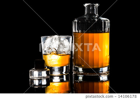 Whiskey on the rocks, with a whiskey bottle isolated in dark background 14106178