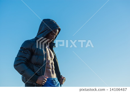 Muscular African black male wearing black bomber jacket hoodie with zipper, isolated with blue sky Muscular African black male wearing black bomber jacket hoodie with zipper, isolated with blue sky 14106487