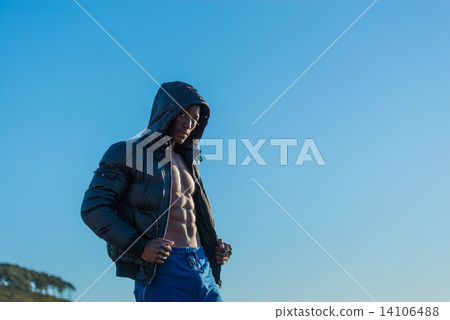 Muscular African black male wearing black bomber jacket hoodie with zipper, isolated with blue sky Muscular African black male wearing black bomber jacket hoodie with zipper, isolated with blue sky 14106488
