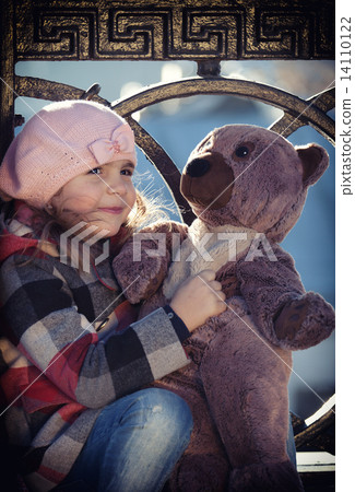 Little girl in a pink beret holds a toy bear Little girl in a pink beret holds a toy bear 14110122