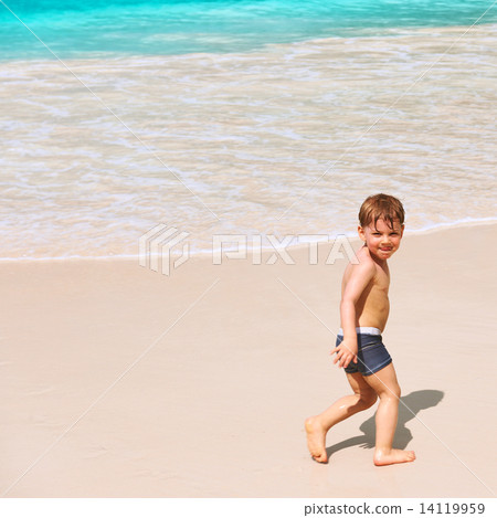 Two year old boy playing on beach Two year old boy playing on beach 14119959