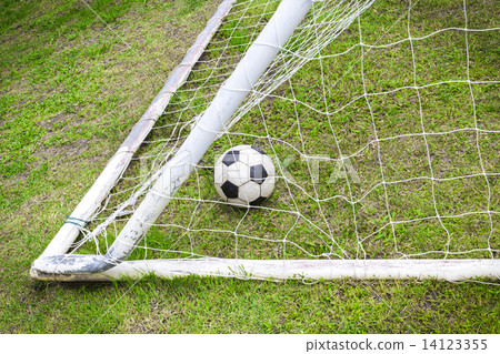 Old soccer ball in old goal net Old soccer ball in old goal net 14123355