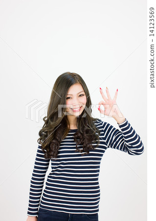 A young woman with a smile who makes an OK sign with the left hand 14123569
