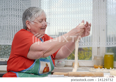 Elderly woman kneading dough 14129732