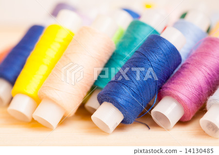 Multicolor threads on wooden background Multicolor threads on wooden background 14130485