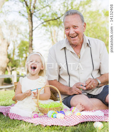 Grandfather and Granddaughter Coloring Easter Eggs on Blanket At 14132408
