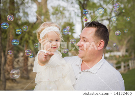 Father Holding Baby Girl Enjoying Bubbles Outside at Park Father Holding Baby Girl Enjoying Bubbles Outside at Park 14132460