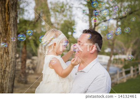 Father Holding Baby Girl Enjoying Bubbles Outside at Park Father Holding Baby Girl Enjoying Bubbles Outside at Park 14132461