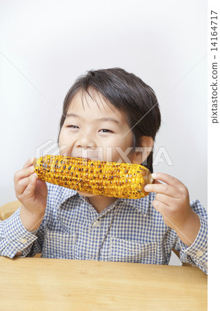 A child eating corn 14164717