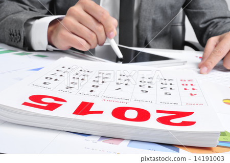 man in suit using a tablet and a 2015 calendar 14191003