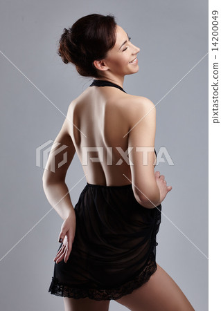 Rear view of smiling woman posing in sexy negligee 14200049
