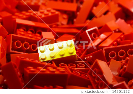 Pile of red color building blocks with selective focus and highlight on one yellow block 14201132