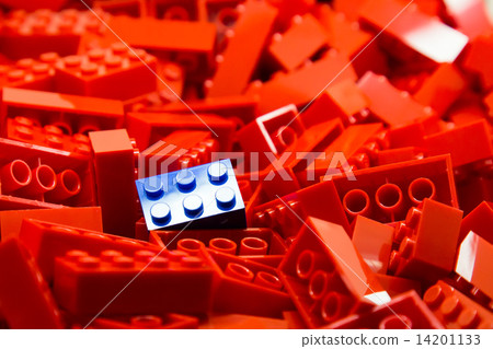 Pile of red color building blocks with selective focus and highlight on one blue block 14201133