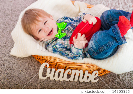 Child in the bow tie is in the basket with a blanket 14205535