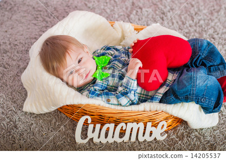 Child in the bow tie is in the basket with a blanket 14205537