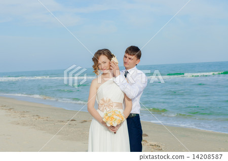 Young bride and groom on the beach in summer 14208587