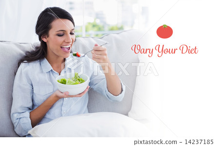 Vary your diet against happy woman relaxing on the sofa eating s Vary your diet against happy woman relaxing on the sofa eating s 14237185