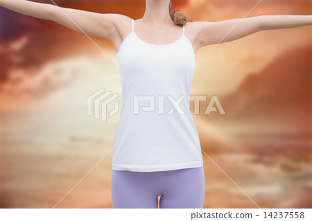 Composite image of woman standing with arms raised on countrysid 14237558