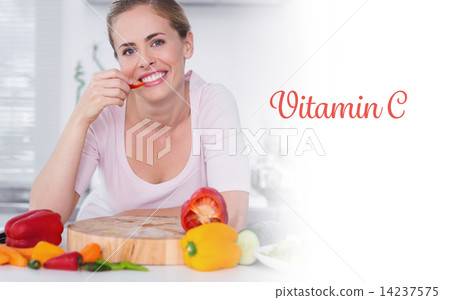 Vitamin c against cheerful woman eating vegetables 14237575