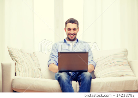 smiling man working with laptop at home smiling man working with laptop at home 14238792