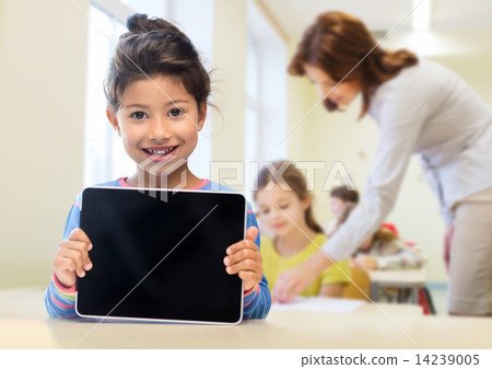 Stock Photo: little school girl with tablet pc over classroom